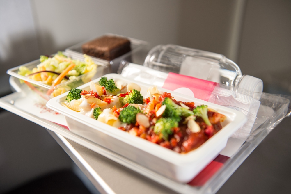 Un agent de bord d’Air Canada Rouge sert le dîner à un couple.